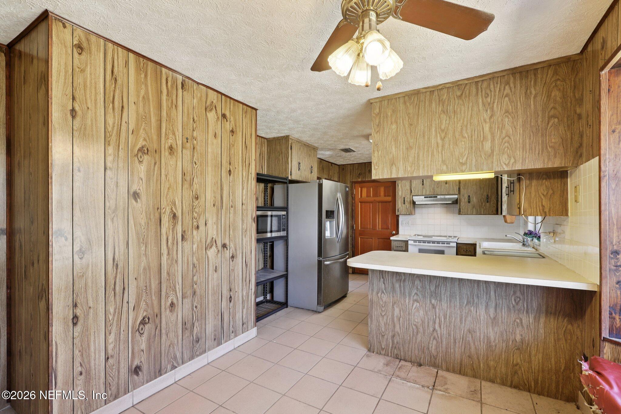 54031 Sheffield Road Callahan, FL 32011 - Photo 19 of 59 a large kitchen with a large window and stainless steel appliances