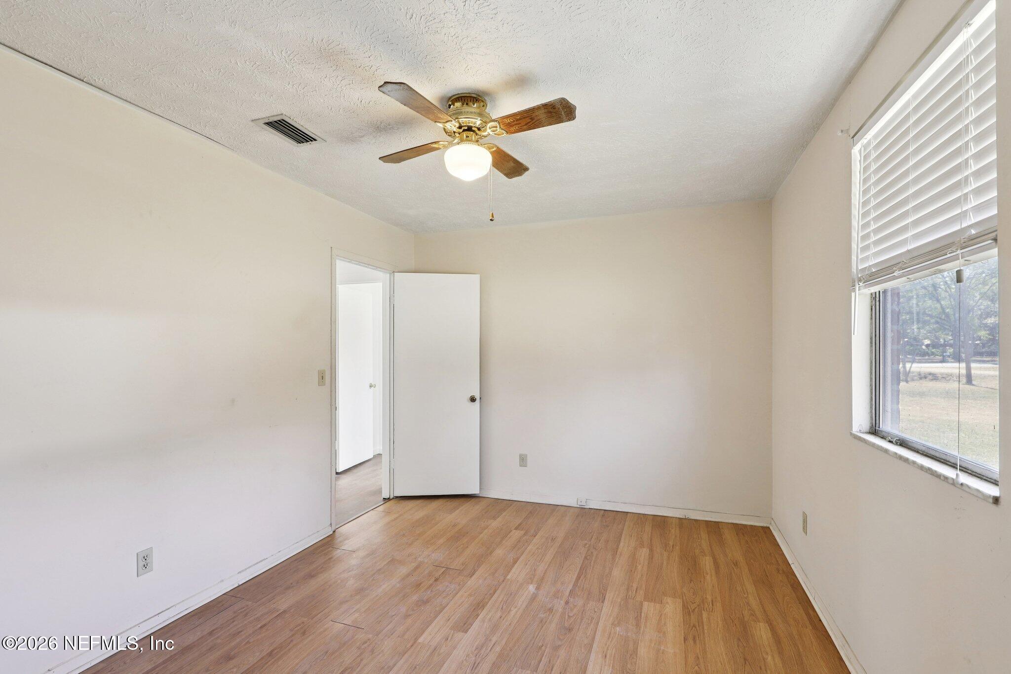 54031 Sheffield Road Callahan, FL 32011 - Photo 26 of 56 an empty room with wooden floor fan and windows