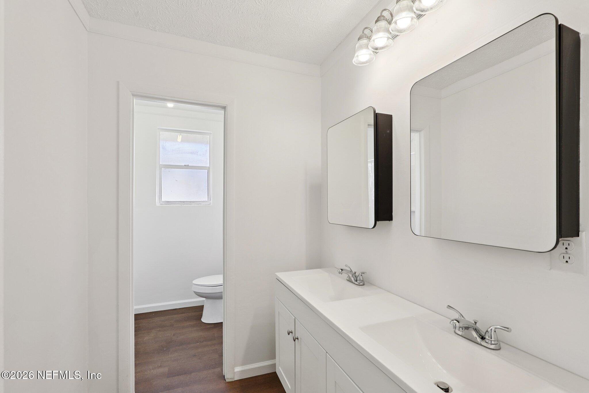 54031 Sheffield Road Callahan, FL 32011 - Photo 27 of 56 a bathroom with a sink a toilet and mirror