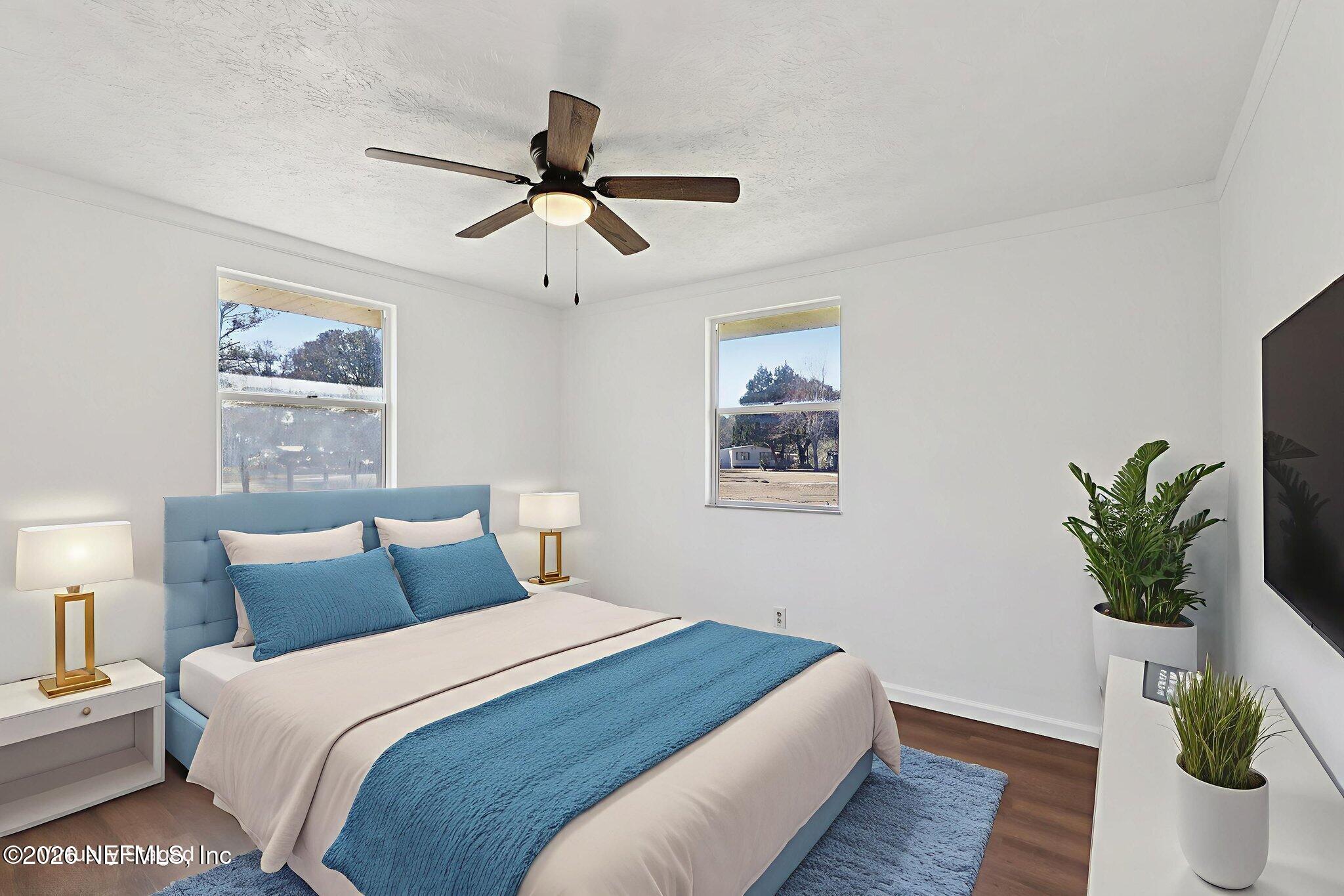 54031 Sheffield Road Callahan, FL 32011 - Photo 35 of 59 a bedroom with a large bed and a potted plant