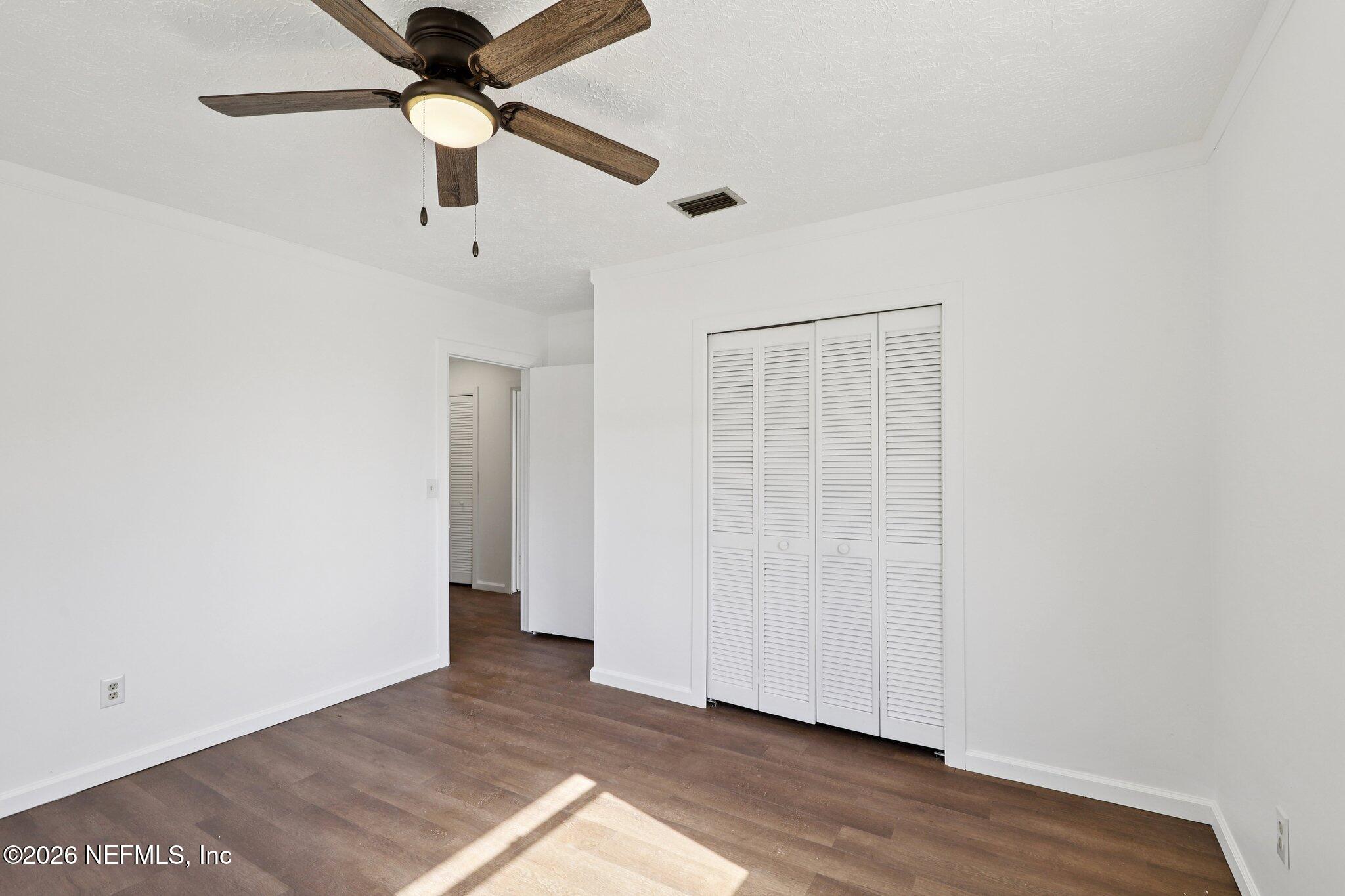 54031 Sheffield Road Callahan, FL 32011 - Photo 37 of 59 an empty room with wooden floor a ceiling fan and closet