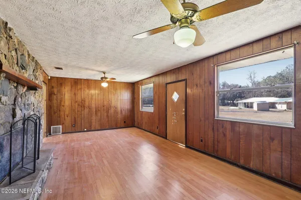 a view of an empty room with wooden floor