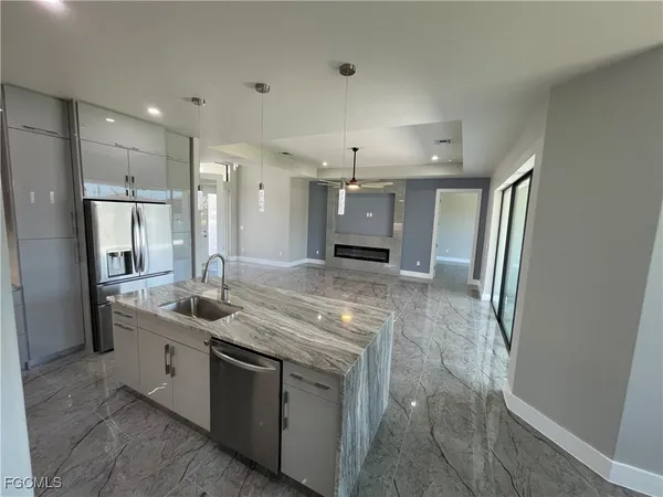 a kitchen with stainless steel appliances granite countertop a sink and a refrigerator