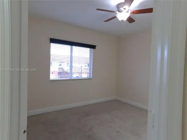 an empty room with a window and a fan