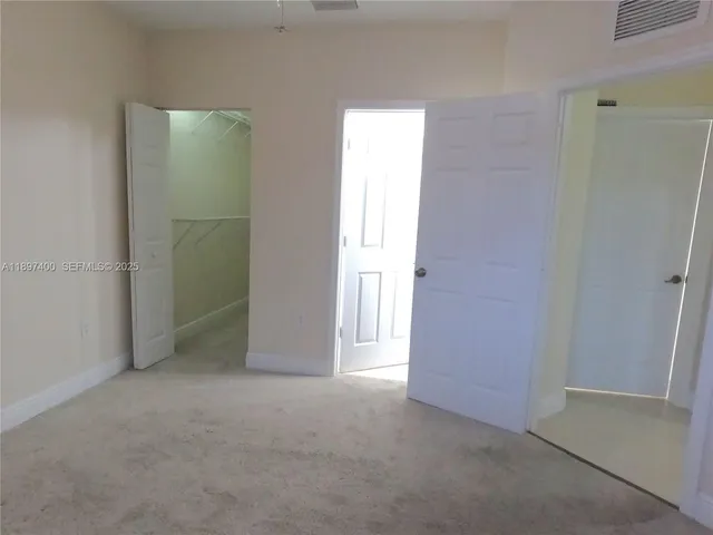 a bedroom with a bed and a flat tv screen on wall