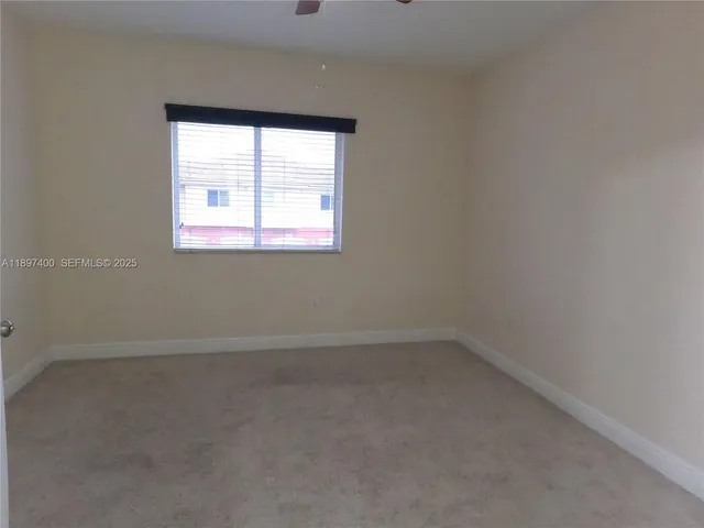 a room with a bed and a lamp on dresser