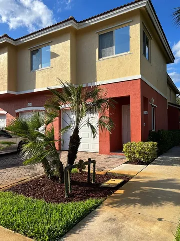 a view of a house with a yard and potted plants