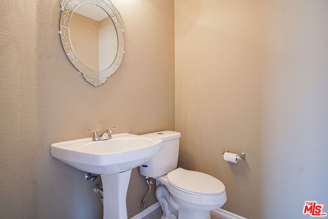14721 Carter Road Victorville, CA 92394 - Photo 14 of 37 a bathroom with a toilet a sink and a mirror