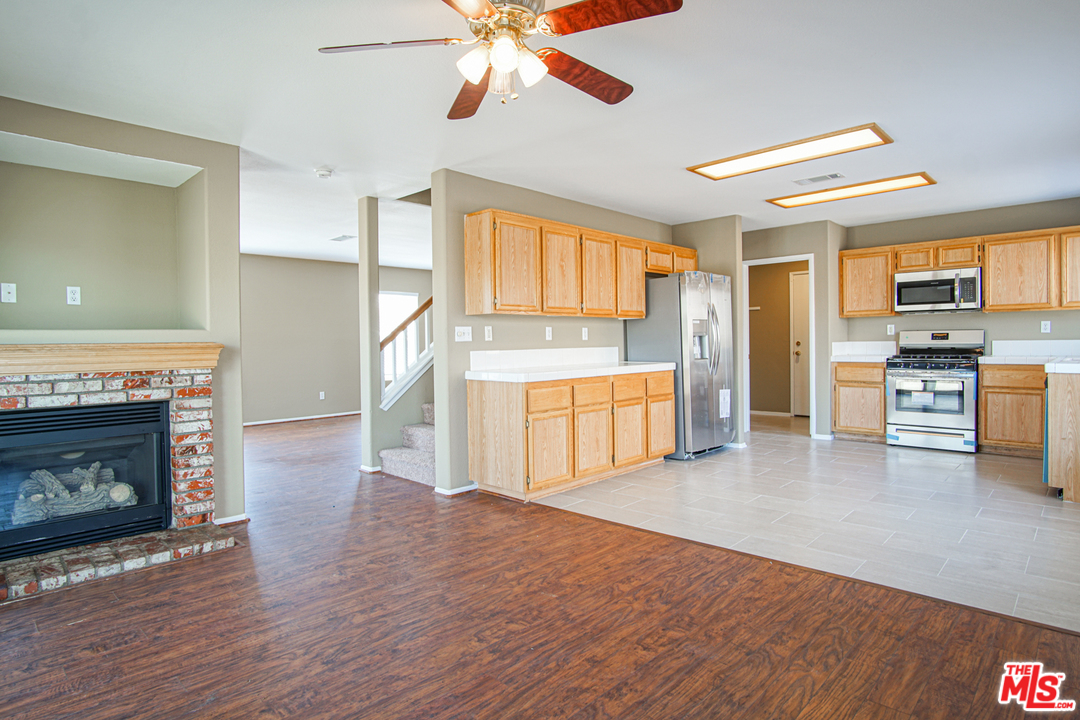 14721 Carter Road Victorville, CA 92394 - Photo 9 of 37 a living room with stainless steel appliances wooden floor and a kitchen