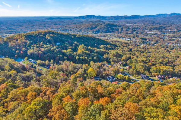 an aerial view of residential house with parking and mountain view