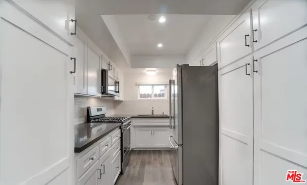 a kitchen with stainless steel appliances a stove a sink and cabinets