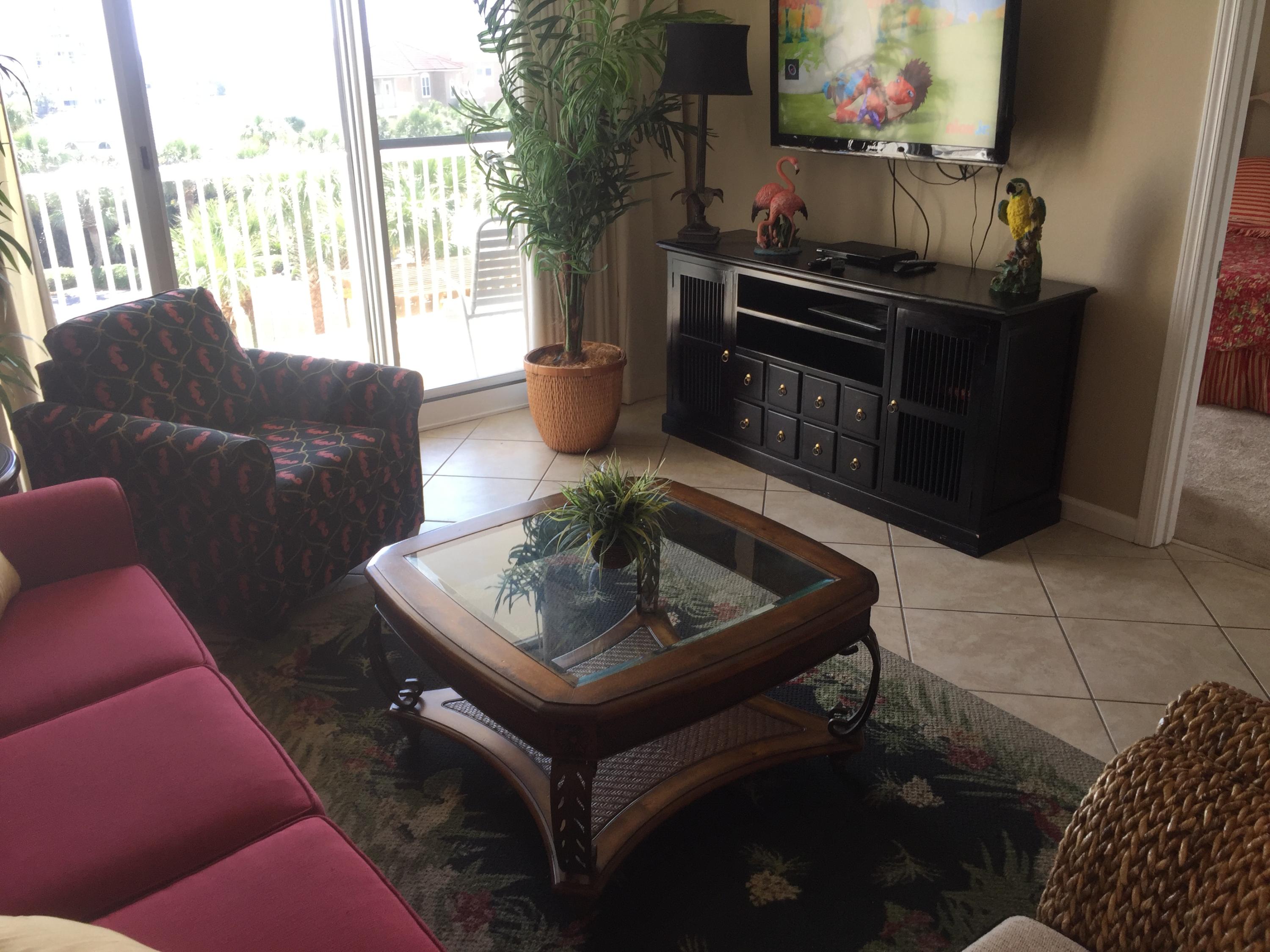 970 Highway 98, Unit 305 Destin, FL 32541 - Photo 12 of 65 a living room with furniture a flat screen tv and a floor to ceiling window