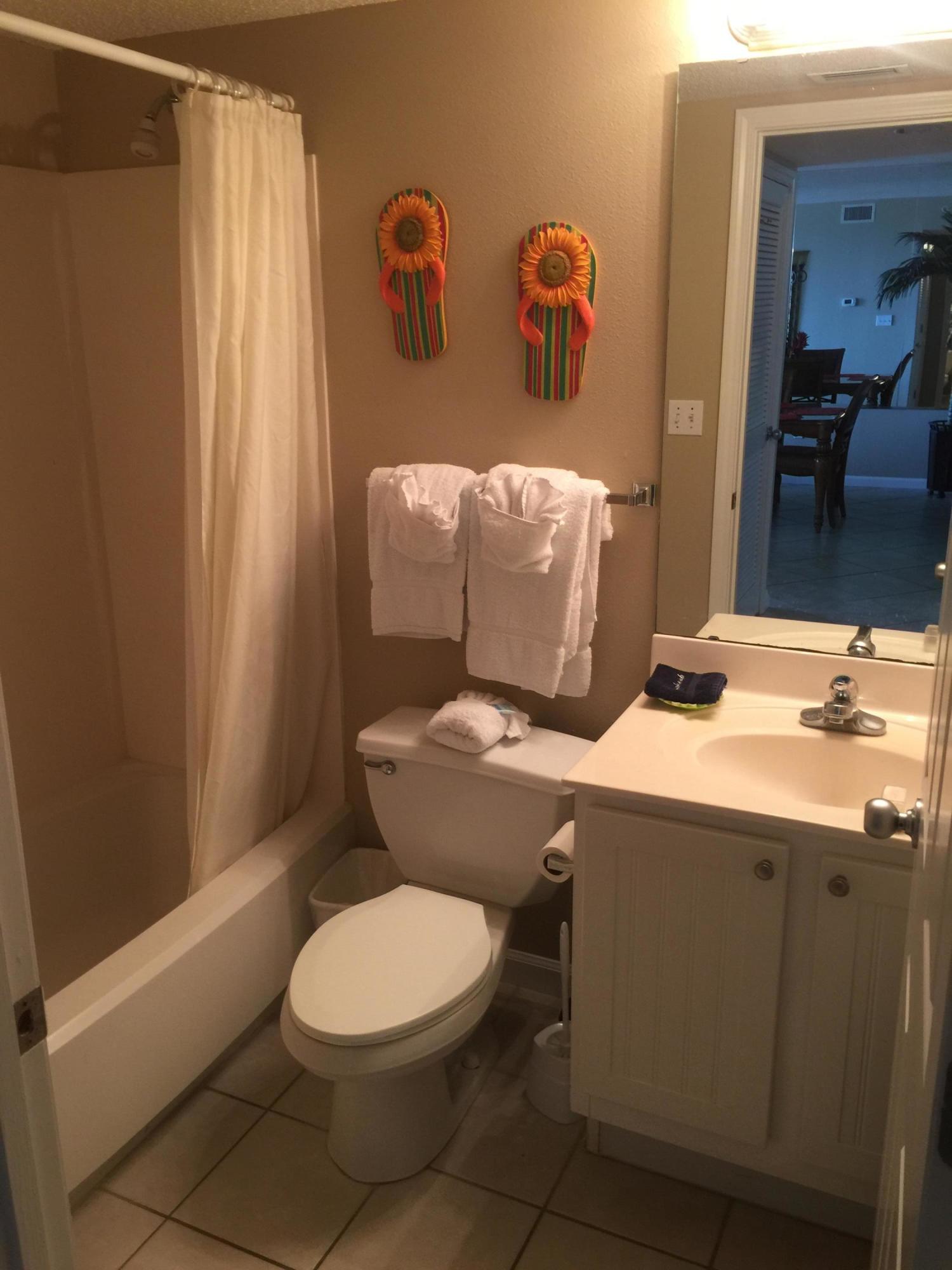 970 Highway 98, Unit 305 Destin, FL 32541 - Photo 26 of 65 a bathroom with a toilet sink and mirror