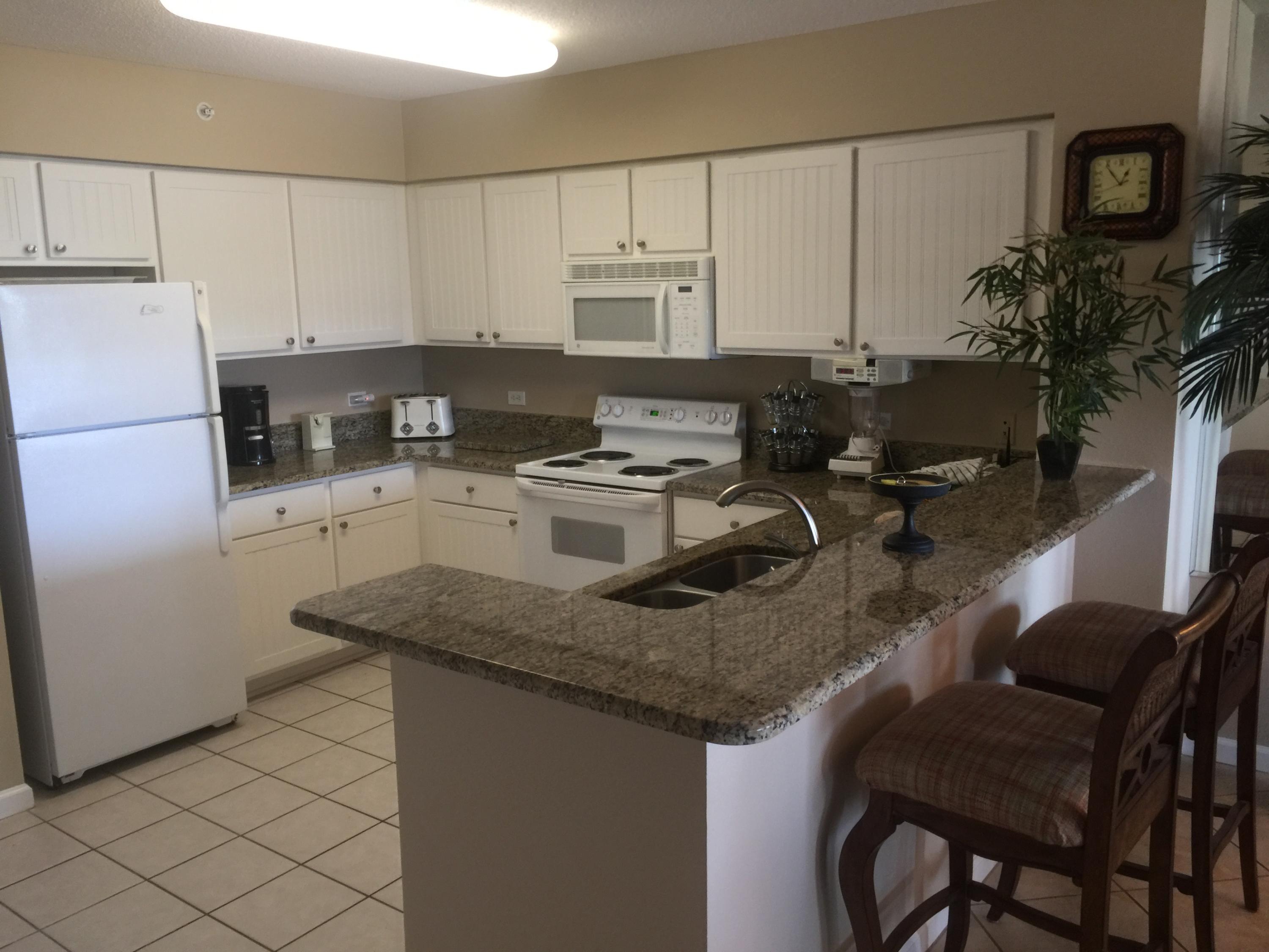 970 Highway 98, Unit 305 Destin, FL 32541 - Photo 4 of 65 a kitchen with granite countertop a sink appliances and cabinets