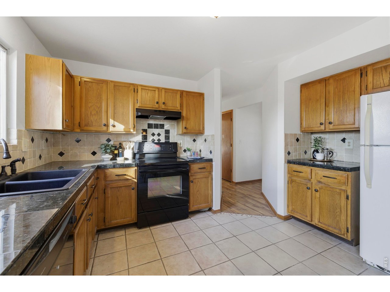 2943 Pleasant Valley Road Fort Collins, CO 80521 - Photo 12 of 38 a kitchen with stainless steel appliances granite countertop a sink a stove a refrigerator cabinets and a window