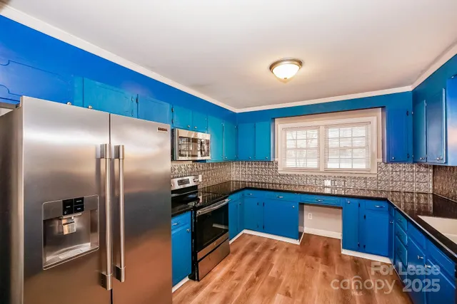 a kitchen with stainless steel appliances granite countertop a sink a stove and refrigerator