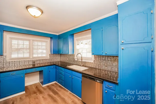 a kitchen with stainless steel appliances granite countertop wooden cabinets a sink and a window