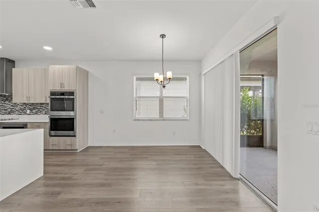a view of a kitchen with a sink cabinet a refrigerator and windows