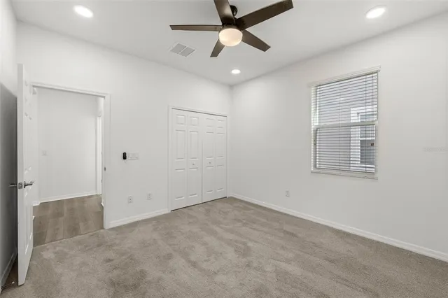 en empty room with ceiling fan and window