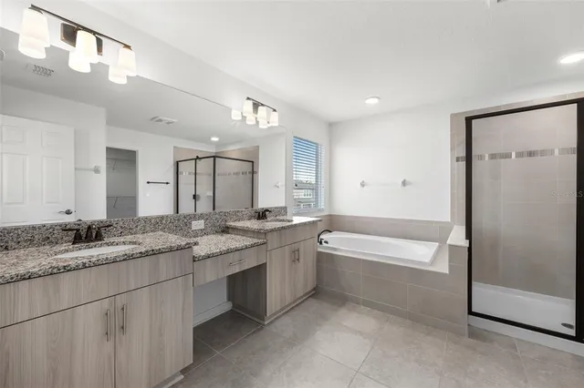 a large bathroom with a granite countertop sink mirror and a bathtub