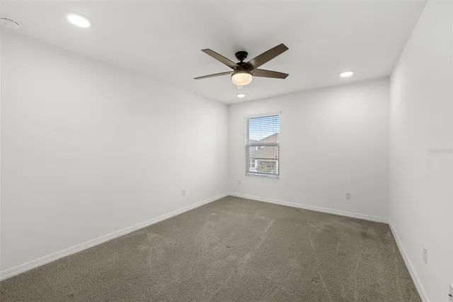 an empty room with a window and a fan