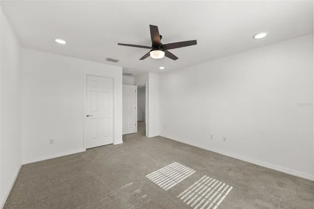 an empty room with a ceiling fan and a window