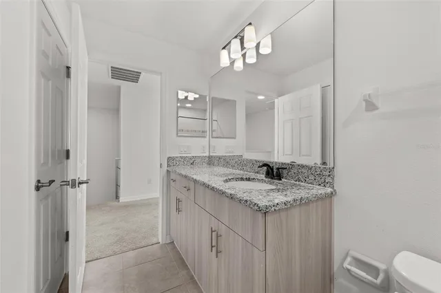 a bathroom with a granite countertop sink and a mirror