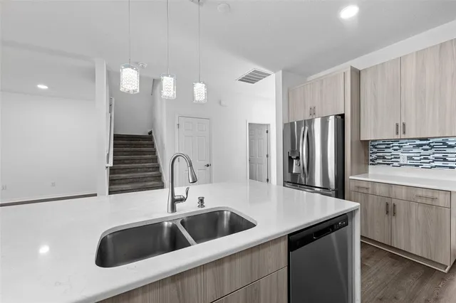 a kitchen with kitchen island a sink and refrigerator
