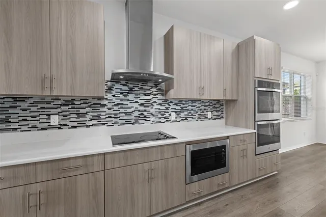 a kitchen with granite countertop white cabinets and stainless steel appliances