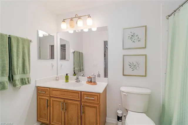 a bathroom with a toilet a sink a large mirror and shower