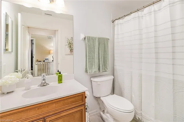 a bathroom with a sink a toilet and shower curtain