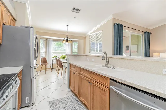 a open kitchen with a sink and dishwasher with chairs