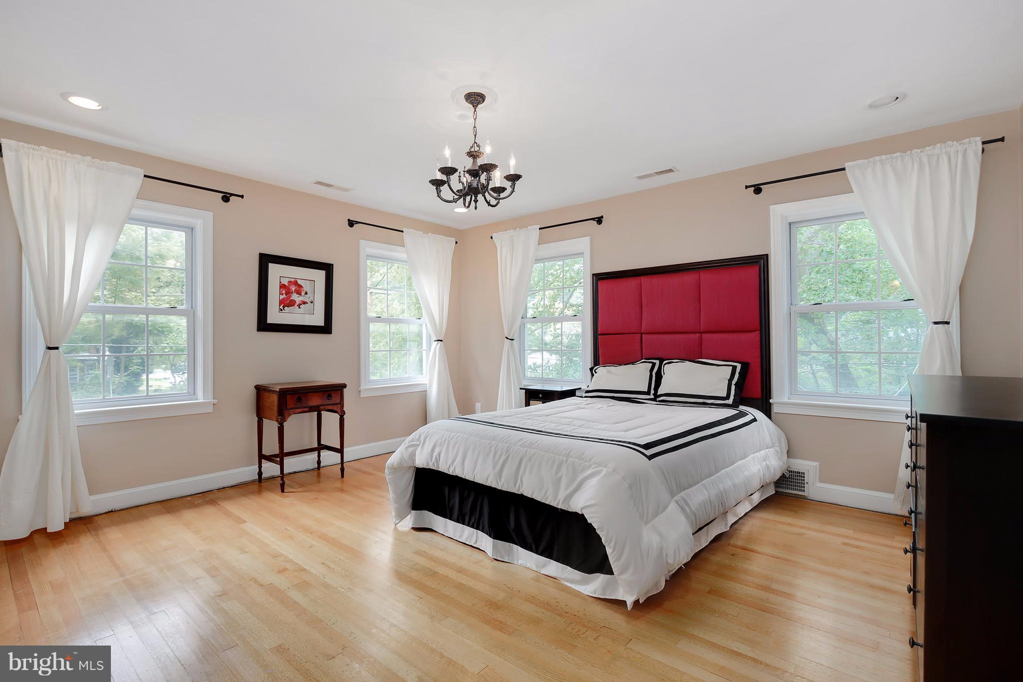 7913 Piney Branch Road Silver Spring, MD 20910 - Photo 17 of 30 a bedroom with a bed windows and a chandelier