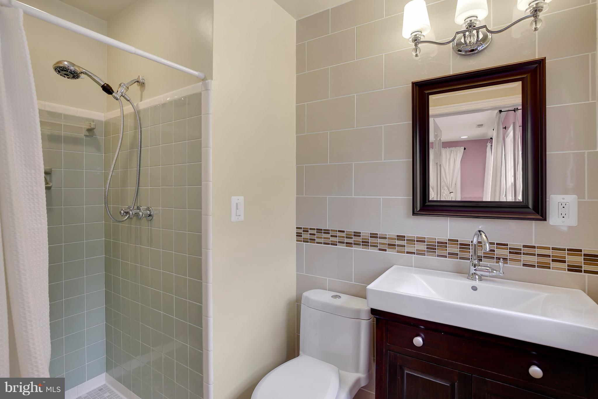 7913 Piney Branch Road Silver Spring, MD 20910 - Photo 19 of 30 a bathroom with a sink a toilet and shower