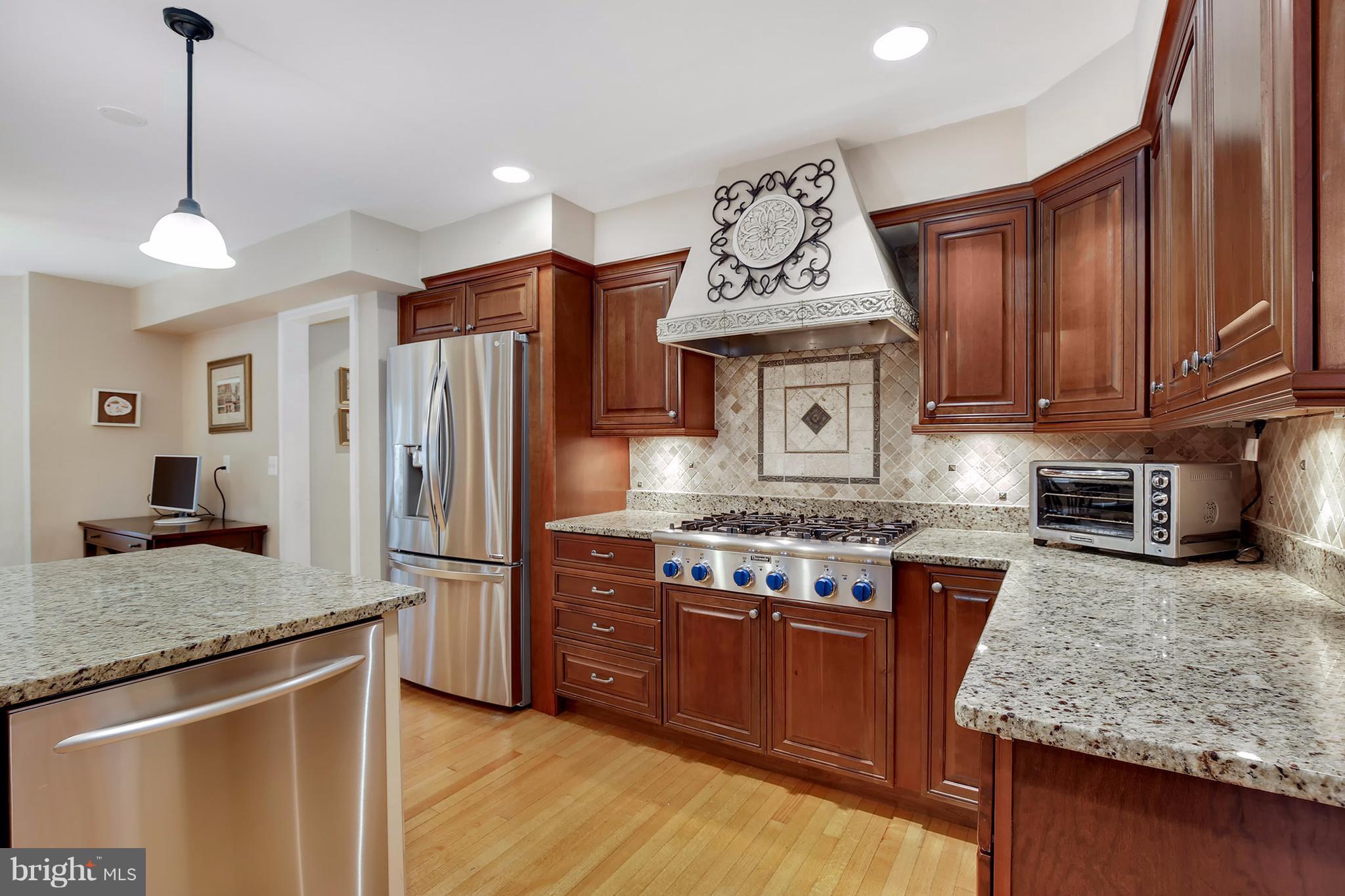7913 Piney Branch Road Silver Spring, MD 20910 - Photo 8 of 30 a kitchen with granite countertop stainless steel appliances and wooden cabinets