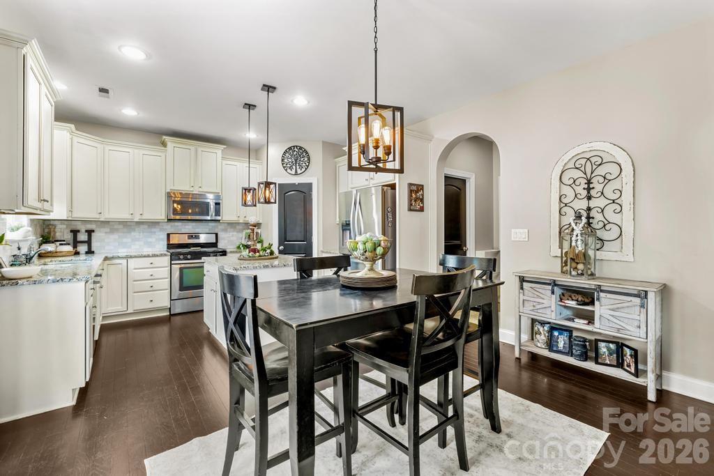 1007 Hamil Ridge Drive Waxhaw, NC 28173 - Photo 23 of 44 a kitchen with stainless steel appliances kitchen island granite countertop a table chairs and a refrigerator