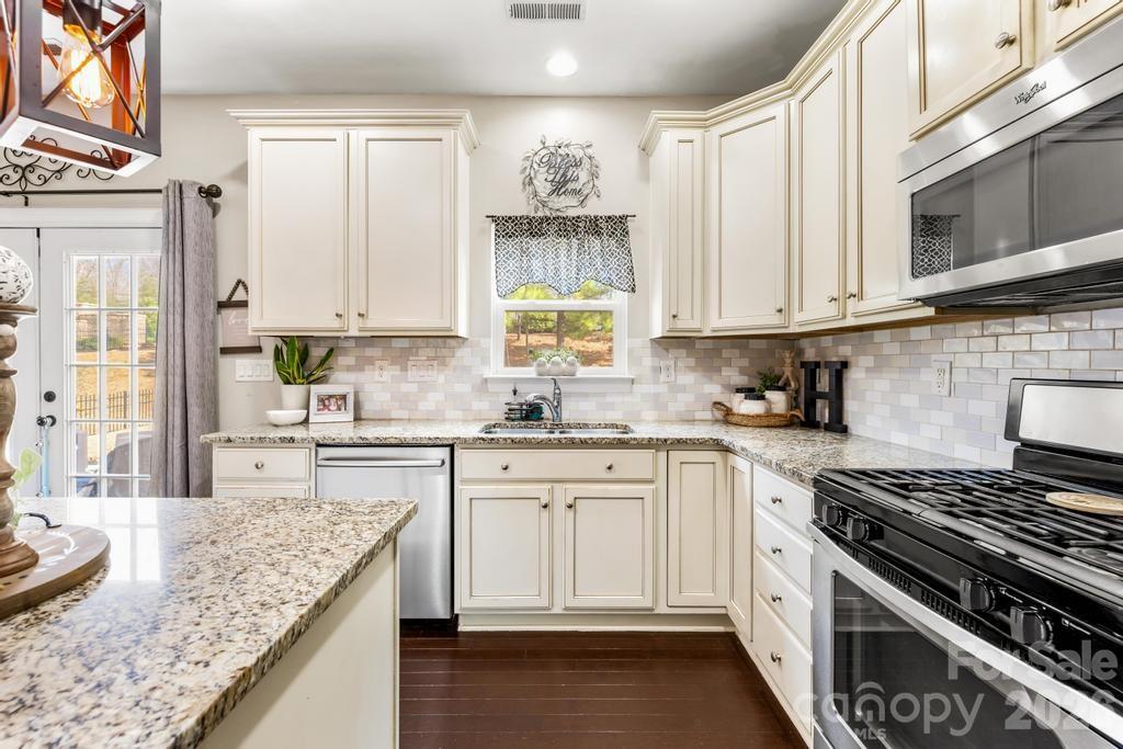 1007 Hamil Ridge Drive Waxhaw, NC 28173 - Photo 26 of 44 a kitchen with stainless steel appliances granite countertop a stove a sink and a white cabinets