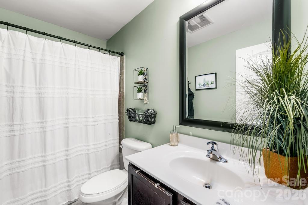 1007 Hamil Ridge Drive Waxhaw, NC 28173 - Photo 38 of 44 a bathroom with a sink a toilet and shower curtain