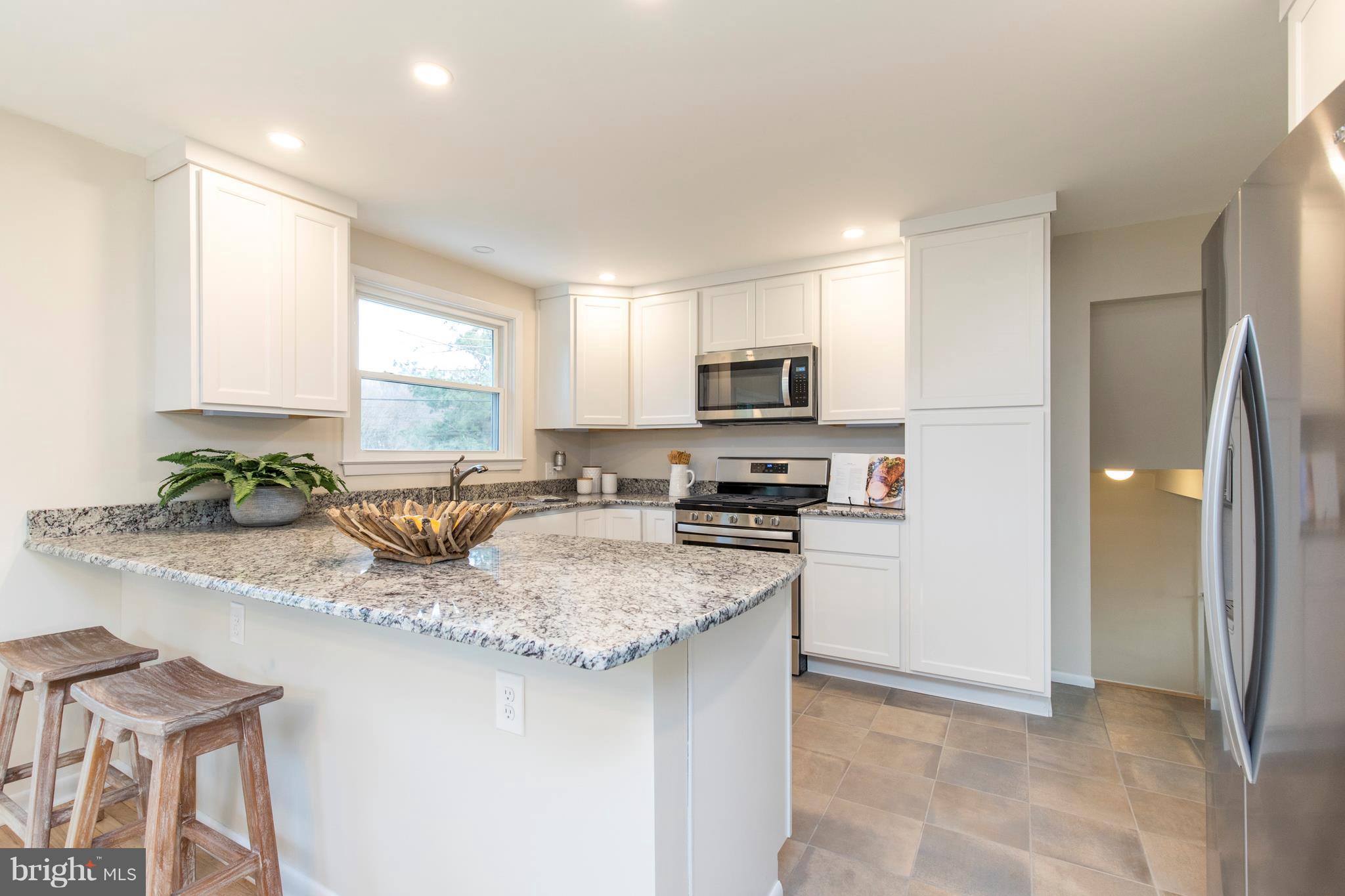 409 Kennerly Road Springfield, PA 19064 - Photo 12 of 41 Bright White Cabinets & Neutral Tile Floor.