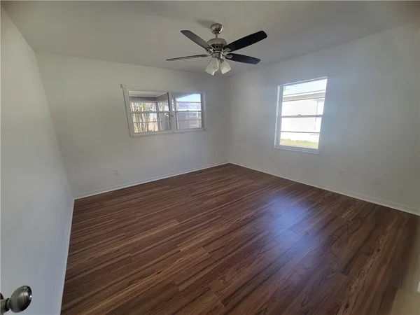 a view of room with window ceiling fan and hardwood floor