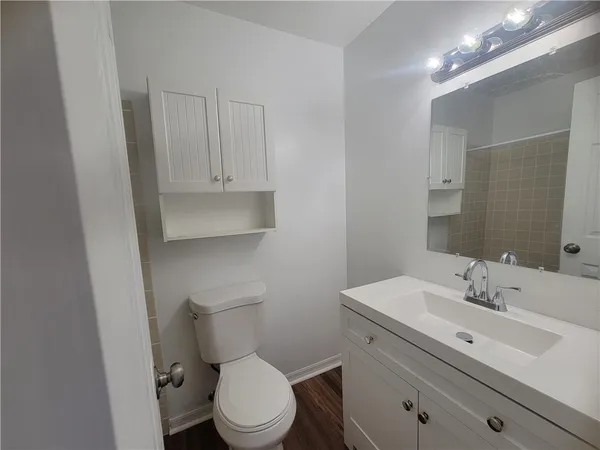 a bathroom with a toilet sink and mirror