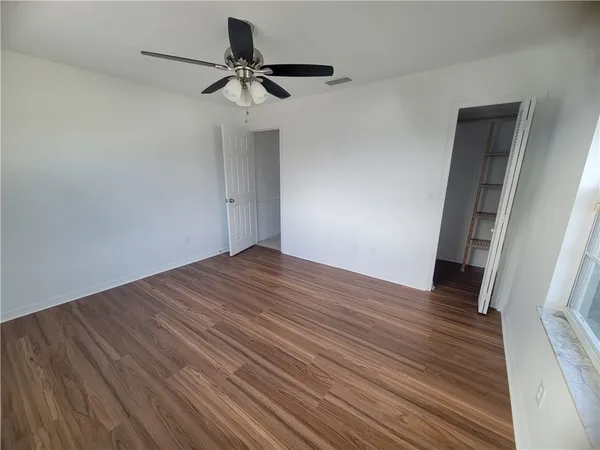 a view of empty room with wooden floor