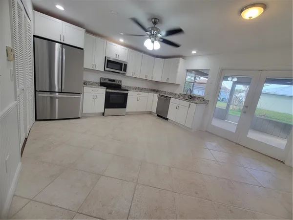 a kitchen with stainless steel appliances granite countertop a refrigerator and a stove top oven