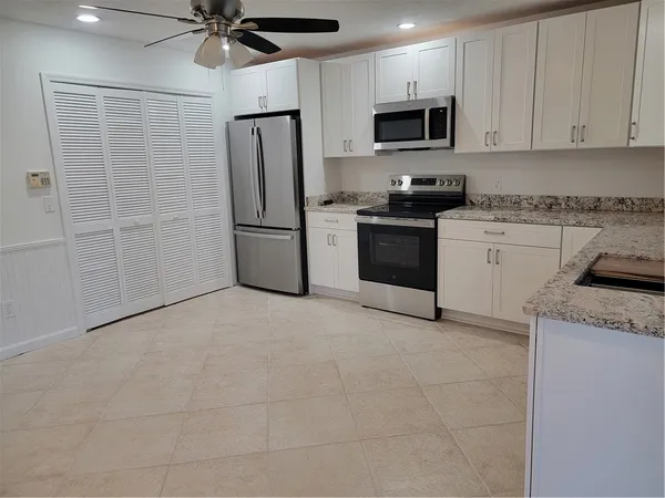 a kitchen with a refrigerator a stove top oven a sink and dishwasher