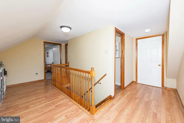 a view of a hallway with wooden floor and stairs