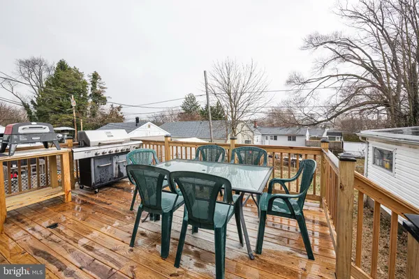 a roof deck with a dining table and chairs with wooden floor