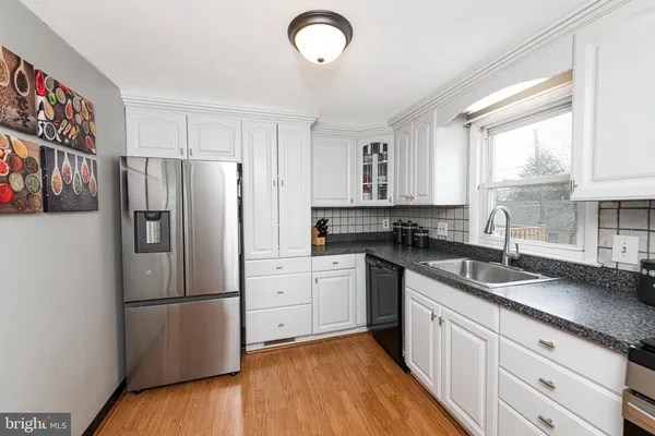 a kitchen with granite countertop stainless steel appliances a refrigerator sink and microwave