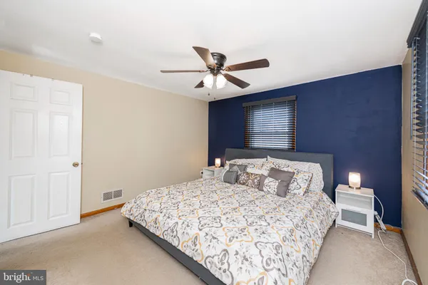 a bedroom with a bed and a ceiling fan