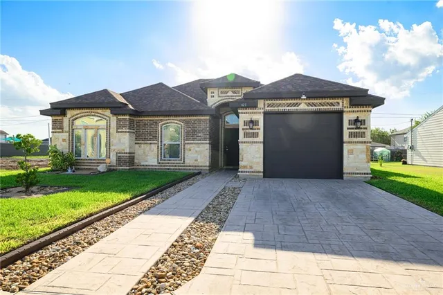 a front view of a house with a yard and garage