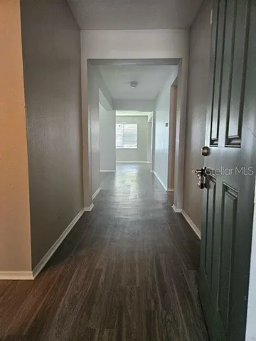 a view of a hallway with wooden floor